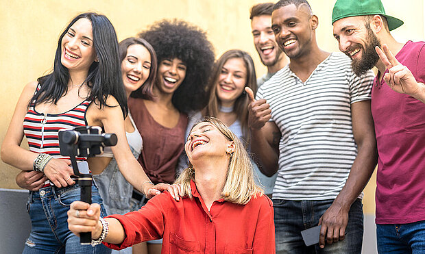 De jeunes amis multiraciaux prennent des photos pour les partager sur les médias sociaux.